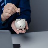 a-person-is-holding-a-piggy-bank-saving-money-and-managing-personal-finances-concept-of-increasing-e1703697767341.jpg