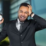 black-businessman-with-alarm-clock-time-management-concept-e1706687943759.jpg