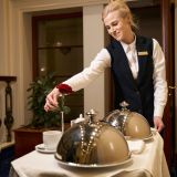 caring-waitress-in-uniform-delivers-food-to-a-hotel-room-e1706537575570.jpg