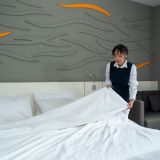 professional-maid-changing-bedclothes-in-a-room-hotel-hotel-room-service-e1706518887432.jpg