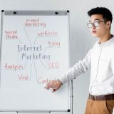 seo-manager-pointing-with-hand-at-flipchart-with-concept-words-of-internet-marketing-e1703408925667.jpg